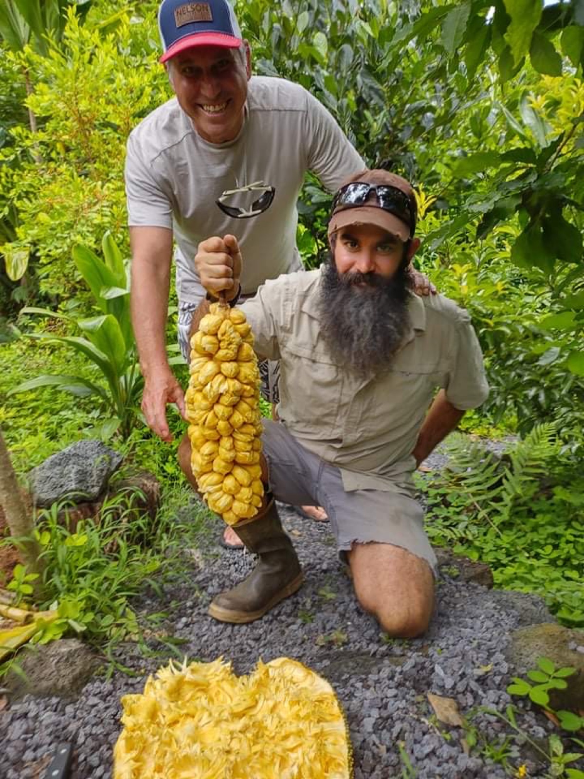 Two growers holding a large tropical fruit harvest at Shaka Farms